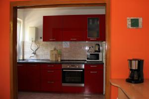 a red kitchen with red cabinets and a microwave at Eros Rooms in Split