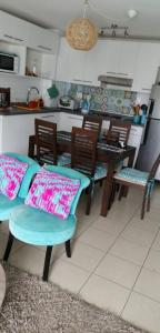 cocina con mesa, sillas y almohadas en Departamento Crystal Lagoons, en Papudo