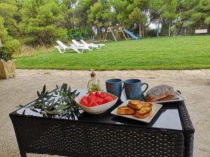 a table with a tray of food and a bowl of fruit at Mas del Olivar in La Portellada