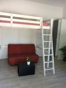 ein Wohnzimmer mit einem Etagenbett und einem roten Sofa in der Unterkunft Castres maisonnette proche du centre ville in Castres