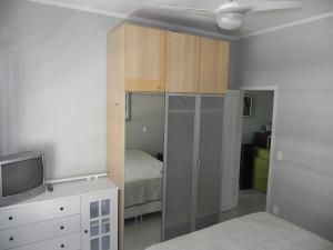 a bedroom with a bed and a cabinet and a tv at Apartamento Djalma Ulrich 1 in Rio de Janeiro