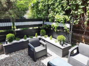 un jardín con 2 sillas y un banco con plantas en Warsztat Apartamenty Stare Izby, en Poronin