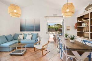a living room with a blue couch and a table at Villa Gloria in Cala'n Bosch