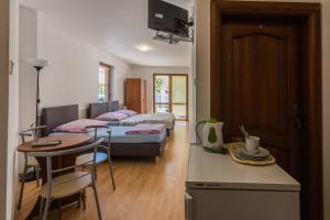 a room with two beds and a kitchen with a table at Willa Mila in Trzęsacz