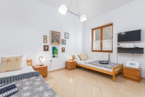 a bedroom with two beds and a flat screen tv at Apartment-Old Town-Dundo in Pula