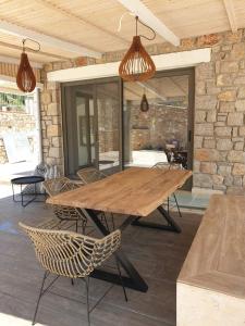 een houten tafel en stoelen op een patio bij Lavender Green Villas in Ayios Nikitas