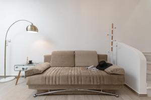 un sofá sentado en una sala de estar junto a una escalera en Elma Kastraki with Pool, en Kastraki Naxou