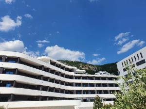 a white building with a mountain in the background at Montenegrina Hotel & SPA All-Inclusive in Becici