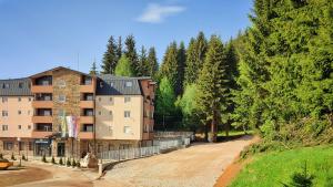 um edifício de apartamentos numa estrada de terra ao lado de árvores em Ema apartman - Zlatar em Nova Varoš
