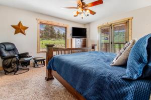 ein Schlafzimmer mit einem Bett und einem Stuhl und einem Fernseher in der Unterkunft Hilltop Hideaway in Garden City