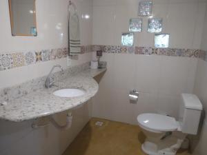 y baño con lavabo y aseo. en Chalé aconchegante em estância climática, en Santo Antônio do Leite