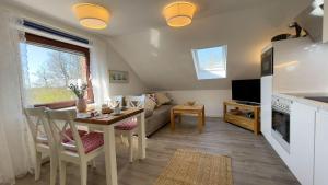 a kitchen and living room with a table and a couch at Strandrobbe-4 in Cuxhaven