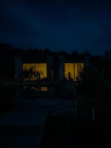 une personne debout devant une maison la nuit dans l'établissement Brown, à Penmarcʼh