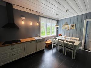a kitchen with a table and a dining room at Trollveggen Stasjon in Åndalsnes
