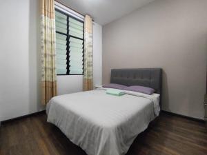 a bedroom with a large bed and a window at Cozzyhome@REX BDC in Kuching