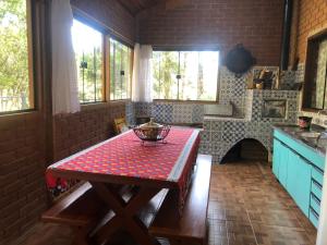 a kitchen with a table with a red table cloth at Casa de Campo Meu Pequeno Paraíso in Gonçalves +32 photos