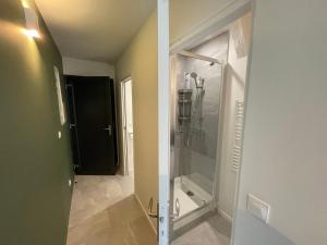 ein Bad mit einer ebenerdigen Dusche und einer Glastür in der Unterkunft Loft central climatisé avec verrière in Vernon