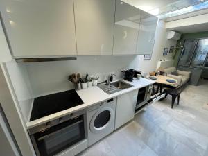 een keuken met een wastafel en een wasmachine bij Loft central climatisé avec verrière in Vernon
