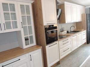 una cocina blanca con armarios blancos y fregadero en House at the lake in Nowogard en Wyszomierz