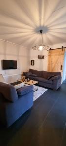 a living room with two couches and a ceiling at Gite Haras du Bois de Formerie in Formerie