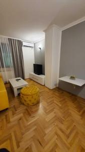 a living room with a wooden floor and a couch at Apartment Denza City Center Sarajevo in Sarajevo