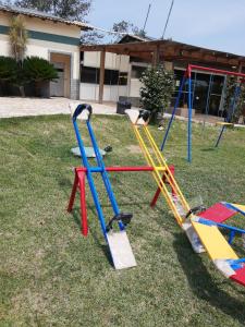 a group of swings on the grass in a yard at Parque Aldeia das Águas Flat in Barra do Piraí