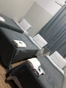 2 Betten in einem Zimmer mit Handtüchern darauf in der Unterkunft Ágape Hotel in Rio Verde