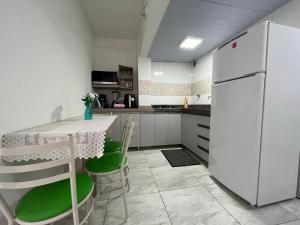 uma cozinha com um frigorífico branco, uma mesa e cadeiras em MA01- Kitnet com Ar | Vista Big Wheel | Garagem em Balneário Camboriú