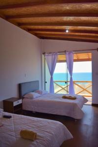 1 dormitorio con 2 camas y vistas al océano en LIOMS HOME, en Vichayito