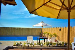 a patio with a table and chairs and an umbrella at LIOMS HOME in Vichayito