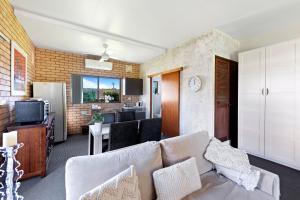 a living room with a couch and a kitchen at Fi's Beach House in Port Macquarie