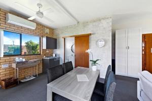 a kitchen and dining room with a wooden table and chairs at Fi's Beach House in Port Macquarie