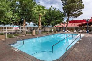 a swimming pool at a resort with trees at Best Western Swiss Clock Inn in Pecos