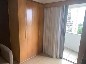 Lindo Flat na Barra da Tijuca com vista para o mar في ريو دي جانيرو: غرفة مع خزانة خشبية كبيرة ونافذة +7 صور