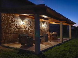 a pavilion with chairs on a patio at night at A CASA DO SABUGUEIRO in Rábeda