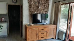 a television on top of a wooden cabinet in a kitchen at Bungalow de Pluumpot in Scherpenisse