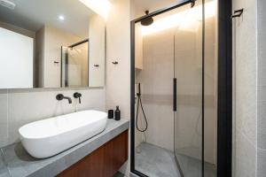 y baño con lavabo y ducha. en The H Experience Blackbird Spacious 2BD Apartment close to the beach, en Xylokastro