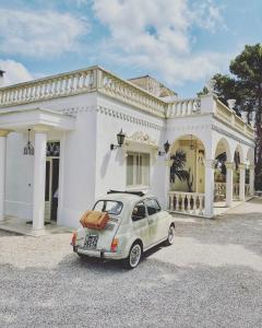 サン・ヴィート・デイ・ノルマンニにあるMasseria Principe di Pugliaの白い家の前に停車する小型車