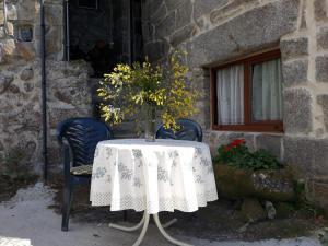 una mesa con un mantel blanco y un jarrón en ella en Casa de pueblo en San Estevo Ribas de Sil, en Ourense