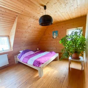 ein Schlafzimmer mit einem Bett in einem Holzzimmer in der Unterkunft Dom caloroczny w Szymbarku in Szymbark