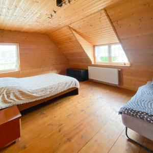 1 Schlafzimmer mit 2 Betten in einem hölzernen Dachgeschoss in der Unterkunft Dom caloroczny w Szymbarku in Szymbark