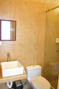 a bathroom with a white toilet and a sink at LIOMS HOME in Vichayito