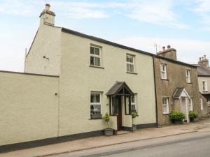 a white brick house on the side of a street at Mulberry Cottage in Grange Over Sands