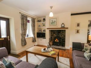 uma sala de estar com um sofá e uma lareira em Mulberry Cottage em Grange Over Sands