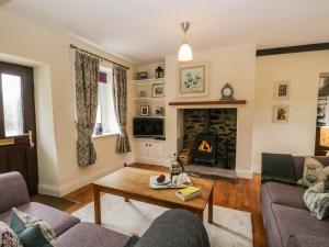 a living room with a couch and a fireplace at Mulberry Cottage in Grange Over Sands