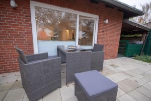 un patio con sillas de mimbre, una mesa y una ventana en Im-Wiesengrund, en Cuxhaven