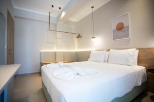 um quarto com uma cama branca e toalhas em Marineiko Luxury Apartments em Ierissos