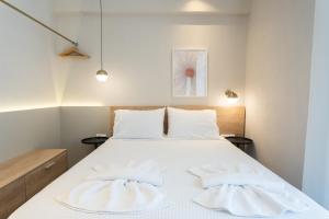 um quarto com uma cama branca e 2 almofadas em Marineiko Luxury Apartments em Ierissos
