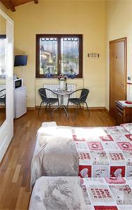 sala de estar con cama y mesa con sillas en Bed & Breakfast Milù, en Cuneo