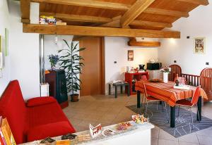a living room with a table and a red chair at Bed & Breakfast Milù in Cuneo